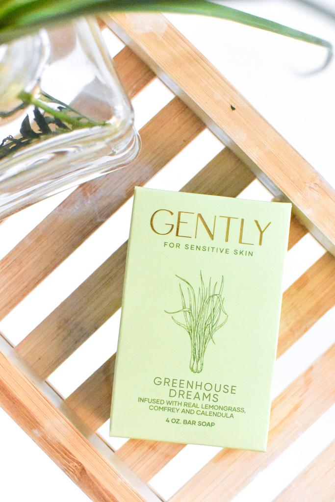 Greenhouse Dreams bath bar on a wooden bath tub tray with grassy florals in a clear vase 