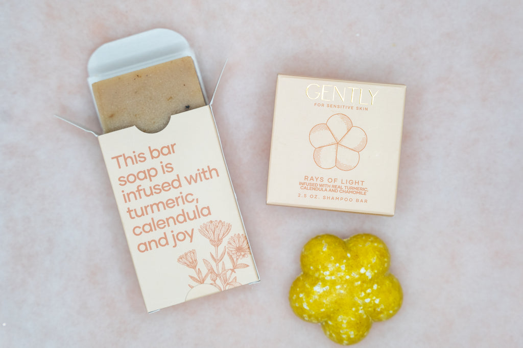 Bar of soap with packaging and a yellow soap bar on a light background